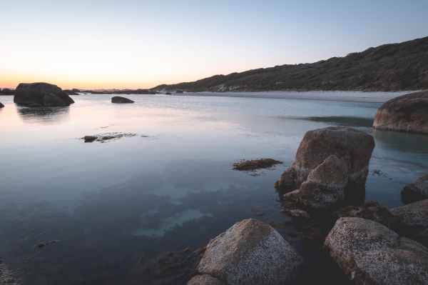 rocky seashore with calm seawater at twilight